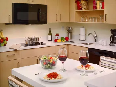 a kitchen with two glasses of wine and a bowl of food at Sonesta ES Suites Princeton in Princeton