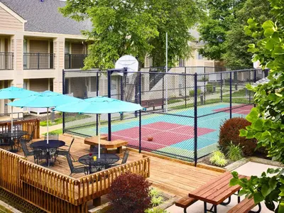 a patio with tables and umbrellas next to a pool at Sonesta ES Suites Princeton in Princeton