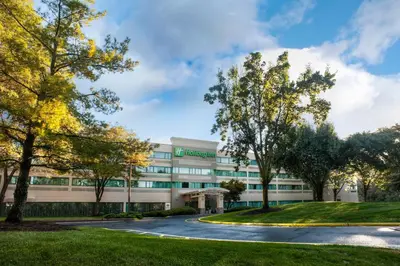 an office building with trees in front of it at Holiday Inn Princeton by IHG in Princeton