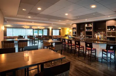 a restaurant with tables and chairs and a bar at Holiday Inn Princeton by IHG in Princeton