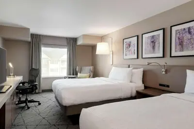 a hotel room with two beds and a desk at Hilton Garden Inn Springfield in Springfield