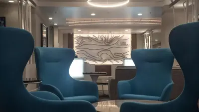 two blue chairs in a waiting room with a painting at Hotel Indigo Harrisburg - Hershey by IHG in Harrisburg