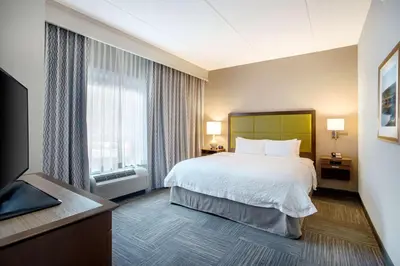 a hotel room with a bed and a large window at Hampton Inn Middletown in Middletown