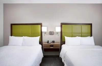 a hotel room with two beds and a desk at Hampton Inn Middletown in Middletown