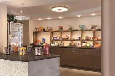 a kitchen with a counter and shelves with food at Homewood Suites Harrisburg-West Hershey Area in Mechanicsburg