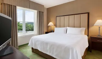 a hotel room with a bed and a television at Homewood Suites Harrisburg-West Hershey Area in Mechanicsburg