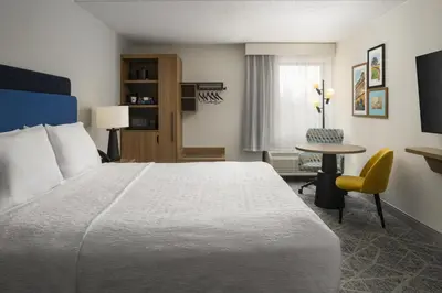 a hotel room with a large bed and a table at Hampton Inn - York in York