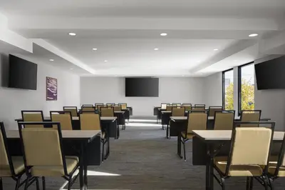 an empty room with tables and chairs and windows at Hampton Inn - York in York
