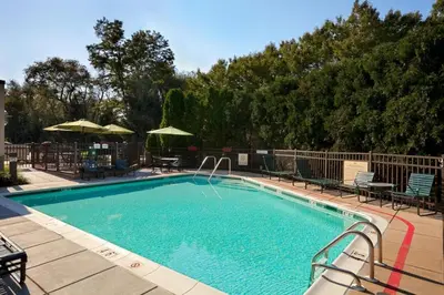 a large swimming pool with chairs and umbrellas at Hampton Inn - York in York