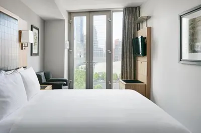 a hotel room with a white bed and a window at Club Quarters Hotel World Trade Center, New York in New York