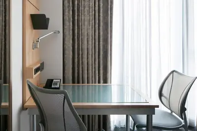 a glass table and chairs in a room with a window at Club Quarters Hotel World Trade Center, New York in New York