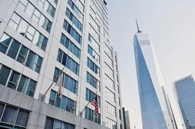 a tall building with an american flag in front of it at Club Quarters Hotel World Trade Center, New York in New York