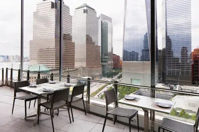 a balcony with tables and chairs and a view of the city at Club Quarters Hotel World Trade Center, New York in New York