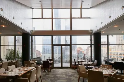 a restaurant with tables and chairs and large windows at World Center Hotel in New York