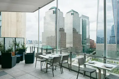 a restaurant with tables and chairs and a view of the city at World Center Hotel in New York
