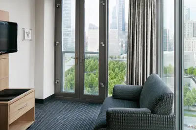 a hotel room with a chair and a large window at World Center Hotel in New York
