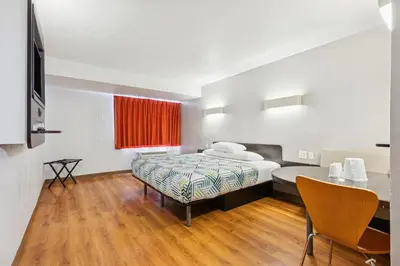 a hotel room with a bed and a table and chair at Motel 6-Piscataway, NJ in Piscataway