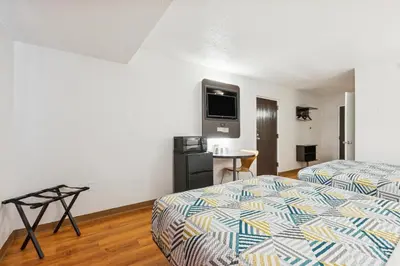 a hotel room with two beds and a tv on the wall at Motel 6-Piscataway, NJ in Piscataway