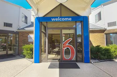 a door to a welcome sign in front of a store at Motel 6-Piscataway, NJ in Piscataway