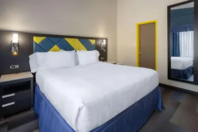 a bedroom with a large bed and a mirror at Days Hotel by Wyndham North Bergen in North Bergen