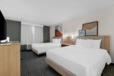 a hotel room with two beds and a flat screen tv at Spark By Hilton Bensalem Philadelphia in Bensalem