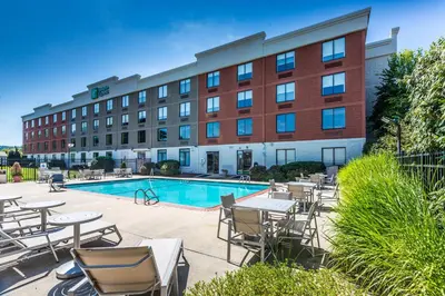 a hotel with tables and chairs next to a pool at Holiday Inn Express Exton - Great Valley by IHG in Exton