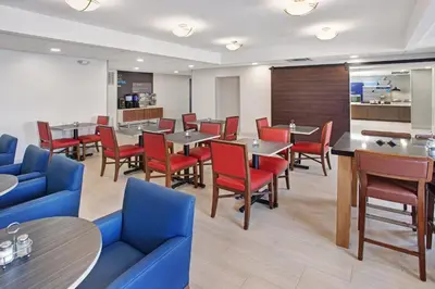 a dining room with tables and red chairs at Holiday Inn Express Exton - Great Valley by IHG in Exton
