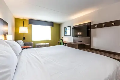 a bedroom with a large white bed and a flat screen tv at Holiday Inn Express Exton - Great Valley by IHG in Exton