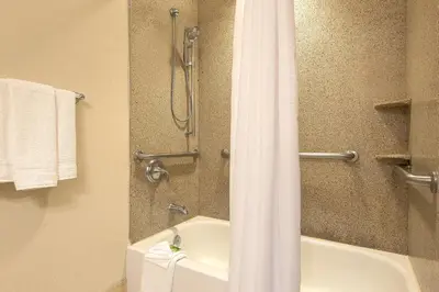 a bathroom with a shower with a white shower curtain at Holiday Inn Express Haskell-Wayne Area by IHG in Haskell