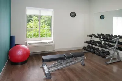 a gym with a bench and a lot of weights at Holiday Inn Express Haskell-Wayne Area by IHG in Haskell