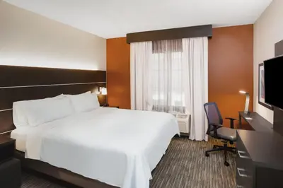 a hotel room with a bed and a desk and a television at Holiday Inn Express Haskell-Wayne Area by IHG in Haskell