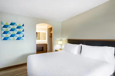 a bedroom with a large white bed and a bathroom at Holiday Inn Express Hotel & Suites Philadelphia - King of Prussia by IHG in King of Prussia