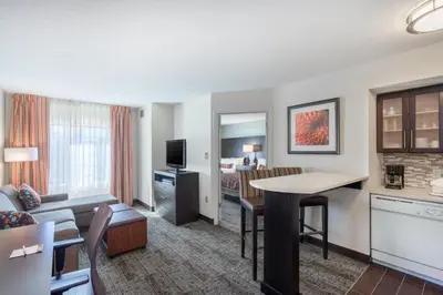 a living room with a couch and a table in a hotel room at Staybridge Suites Wilmington-Newark by IHG in Newark