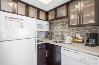 a kitchen with a white refrigerator and a sink at Staybridge Suites Wilmington-Newark by IHG in Newark