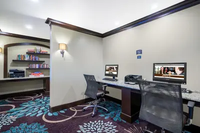 an office with a desk with a computer and chairs at Staybridge Suites Wilmington-Newark by IHG in Newark