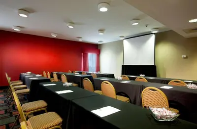 a conference room with tables and chairs and a screen at Hampton Inn Woodbridge in Woodbridge