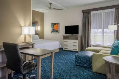 a hotel room with a bed and a couch and a television at Homewood Suites by Hilton Philadelphia Plymouth Meeting in Plymouth Meeting