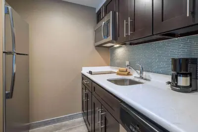 a kitchen with a sink and a refrigerator at Homewood Suites by Hilton Philadelphia Plymouth Meeting in Plymouth Meeting