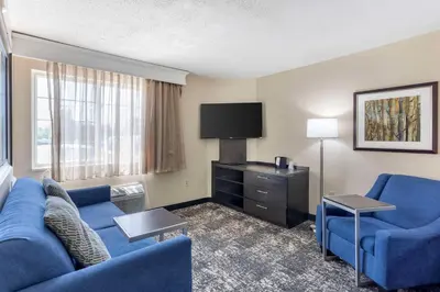 a living room with a blue couch and a tv at Executive Residency by Best Western Philadelphia-Willow Grove in Horsham