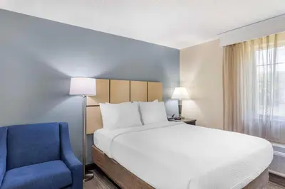 a bedroom with a bed and a blue chair at Executive Residency by Best Western Philadelphia-Willow Grove in Horsham