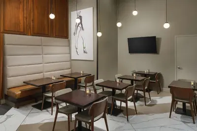 a dining room with tables and chairs and a tv at DoubleTree by Hilton Hotel New York City - Chelsea in New York
