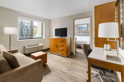a hotel room with a couch and a desk and a bed at DoubleTree by Hilton Hotel New York City - Chelsea in New York