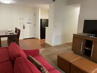 a living room with a red couch and a table and a refrigerator at Hampton Inn & Suites Bethlehem in Bethlehem