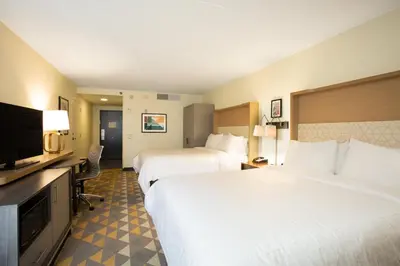 a hotel room with two beds and a flat screen tv at Holiday Inn Morgantown - Reading Area by IHG in Morgantown