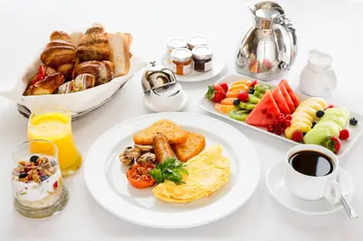 a table topped with plates of breakfast foods and coffee at Crowne Plaza Edison by IHG in Edison