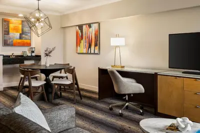 a living room with a couch a table and a tv at Crowne Plaza Edison by IHG in Edison