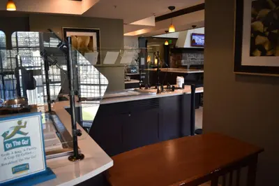 a restaurant with a counter and a table with a sign at Staybridge Suites Cranbury - South Brunswick by IHG in Cranbury