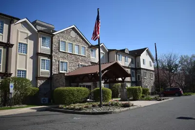 a building with an american flag in front of it at Staybridge Suites Cranbury - South Brunswick by IHG in Cranbury