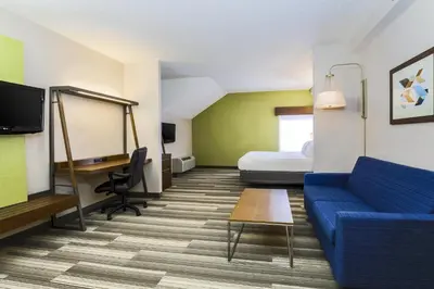 a hotel room with a couch and a bed at Holiday Inn Express Philadelphia NE - Langhorne by IHG in Langhorne