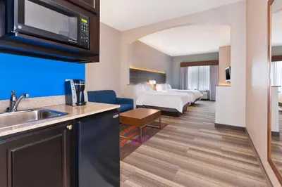 a hotel room with a kitchen and a bedroom at Holiday Inn Express Hotel & Suites Warminster-Horsham by IHG in Warminster